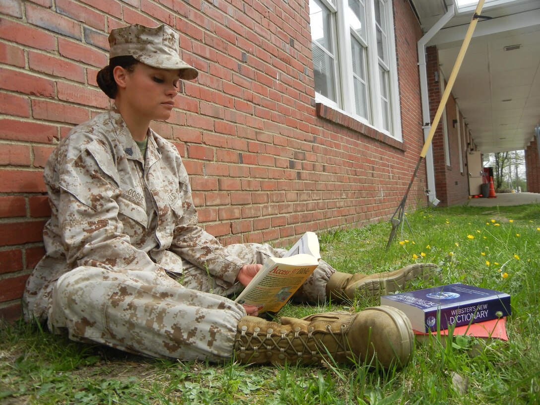 Sgt. Alaura Gogue, a flautist for Quantico Marine Corps Band, reads a book outside the band hall aboard Quantico on April 19, 2013. As of April 8, 2013, the Marine Corps restored the Voluntary Education Tuition Assistance program, which allows degree-seeking Marines to receive a maximum rate of $250 per semester and $4,500 per year toward college courses.              