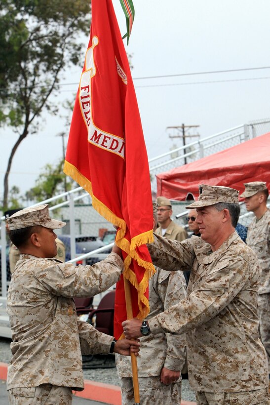 Navy Capt. Dan Cornwell, incoming commanding officer of Field Medical Training Battalion West, hands the colors to Master Chief Petty Officer Harlan B. Patawaran, command master chief of FMTB-West, during a change of command ceremony at Camp Pendleton, June 7. Cornwell relieved Navy Capt. Michael Eby, as the commanding officer of FMTB-West. Eby passed on FMTB-West's guidon to Cornwell signifying his relinquishing of command and Cornwell's new responsibilities.
