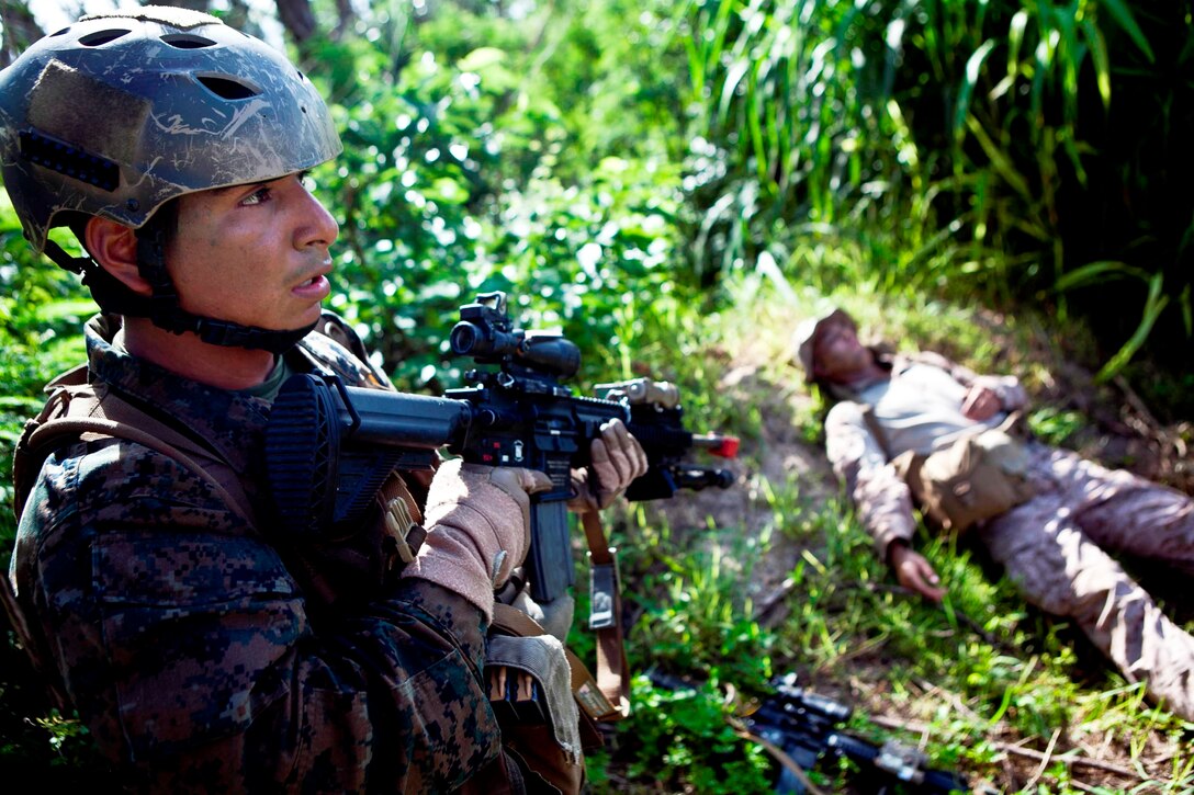 Lance Cpl. Andres Reyes, a rifleman with Company F., Battalion Landing Team 2nd Battalion, 4th Marines, 31st Marine Expeditionary Unit, provides security near a fallen enemy role player during a notional boat raid here, June 8. The training exercise allowed the force to practice every aspect of an amphibious raid, except for the use of a Navy ship as the starting point, before their upcoming deployment. The 31st MEU is the Marine Corps’ force in readiness for the Asia-Pacific region and is the only continuously forward-deployed MEU.
