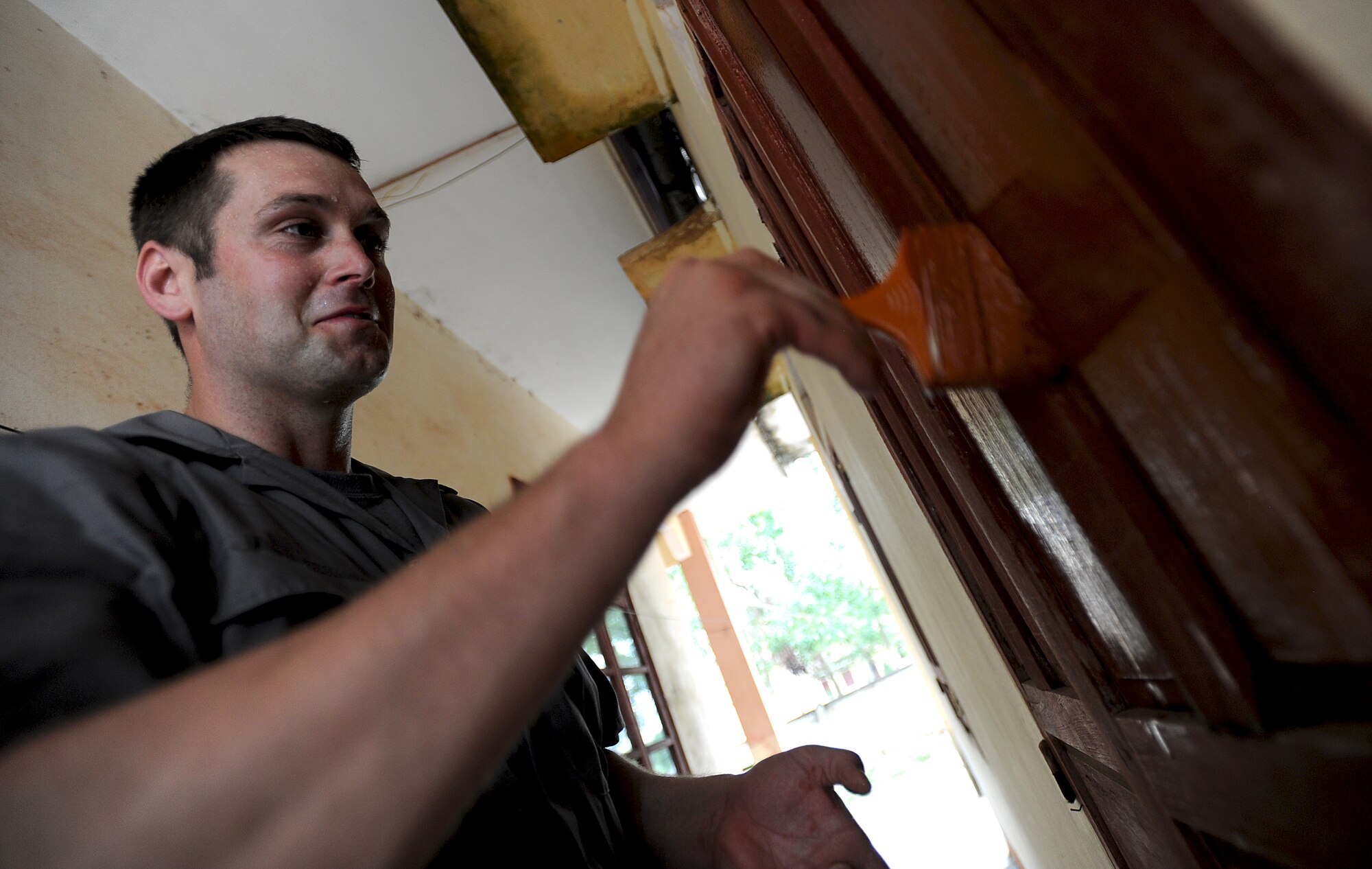 Senior Airman Chris Black, a fire fighter with the 142nd Fighter Wing out of Portland, Oregon, paints shutters for a local school in Dong Hoi, Quang Binh Province, Vietnam as part of Operation Pacific Angel 2013, June 11, 2013. U.S. Military members carry out various construction projects as part of Engineering Civil Action Programs during the operation.  Operation PACANGEL is a joint and combined humanitarian assistance exercise held in various countries several times a year and includes medical, dental, optometry, engineering programs and a variety of subject-matter expert exchanges. (U.S. Air Force photo by Staff Sgt. Sara Csurilla)