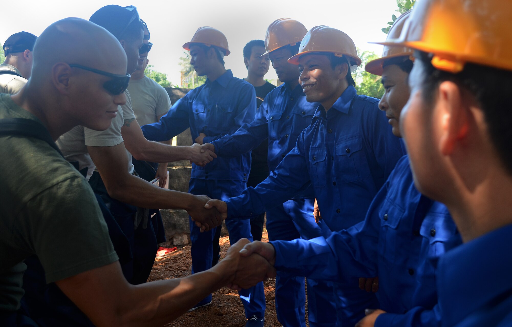 U.S. military members shake hands with local host nation construction workers before doing building repairs during Operation Pacific Angel 2013 in Dong Hoi, Quang Binh Province, Vietnam, June 9, 2013. Operation PACANGEL began June 10 and PACANGEL is a joint and combined humanitarian assistance exercise held in various countries several times a year and includes medical, dental, optometry, engineering programs and a variety of subject-matter expert exchanges. (U.S. Air Force photo by Capt. Sara Greco)