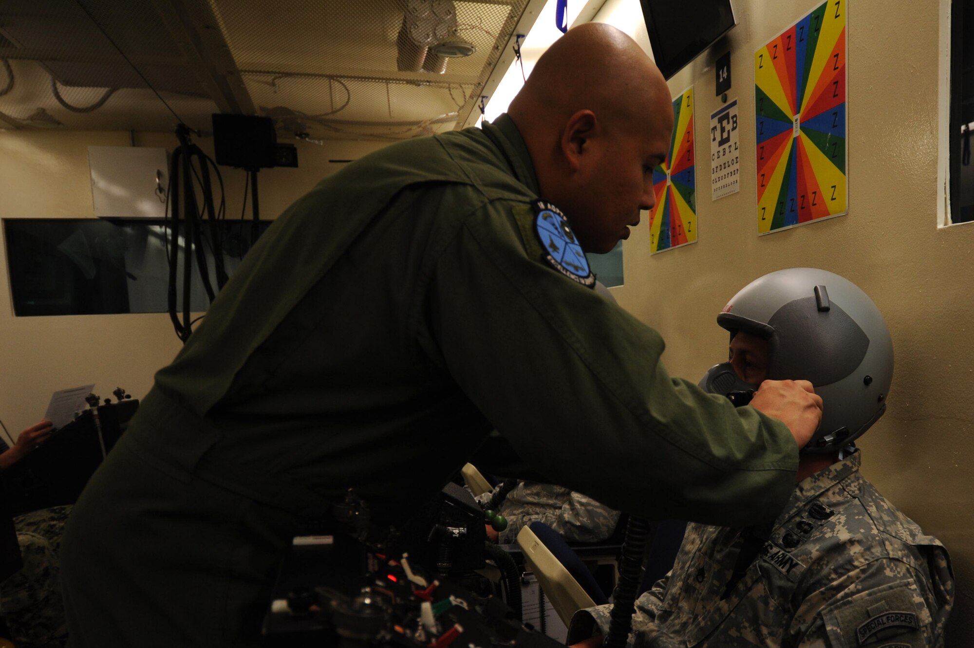 U.S. Air Force Staff Sgt. Nazareth Oliver, 18th Aerospace Medicine Squadron aerospace and operational physiology flight NCO in charge of maintenance, adjusts a face mask in the altitude chamber on Kadena Air Base, Japan, June 11, 2013. The chamber on Kadena recently conducted its final operations. Instead, the aerospace and operational physiology flight will switch to a reduced oxygen breathing device in July, which will be used for refresher training for individuals whose flight qualification currency will expire in the future. (U.S. Air Force photo by Airman 1st Class Hailey R. Davis/Released)