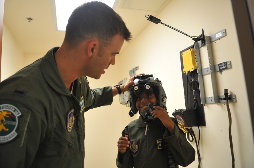 First Lt. Andrew Glowa, 25th Fighter Squadron pilot, ensures the proper fit of a pilot’s helmet on Noah Catman, 10-year-old Osan American Elementary School student, during a Pilot for a Day tour at Osan Air Base, Republic of Korea, June 6, 2013. Whereas similar stateside programs are typically for terminally ill children, this program is unique as an incentive program for students who may need a little academic motivation. (U.S. Air Force photo/Senior Airman Alexis Siekert)