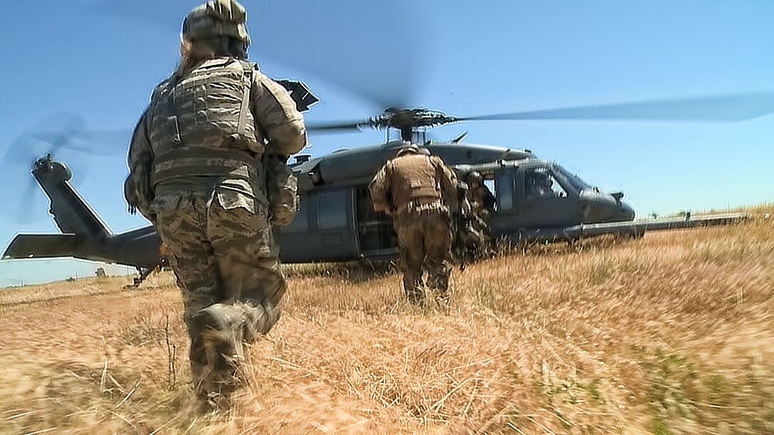 A special operations team races toward a HH-60G Pave Hawk during a combat search and rescue exercise at Beale Air Force Base, Calif., May 31, 2013. The HH-60 Pave Hawk is assigned to the 129th Rescue Wing, Moffett Federal Airfield, Calif.  (U.S. Air Force photo by Staff Sgt. Robert M. Trujillo/Released)