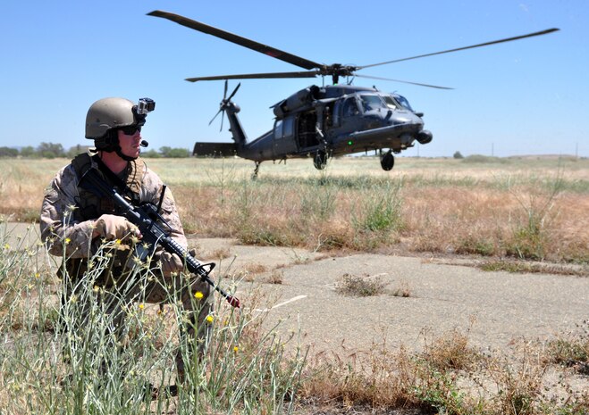 A HH-60G Pave Hawk lands as a special operator provides cover during a combat search and rescue exercise at Beale Air Force Base, Calif., May 31, 2013. The HH-60 Pave Hawk is assigned to the 129th Rescue Wing, Moffett Federal Airfield, Calif.  (U.S. Air Force photo by Robert Scott/Released)