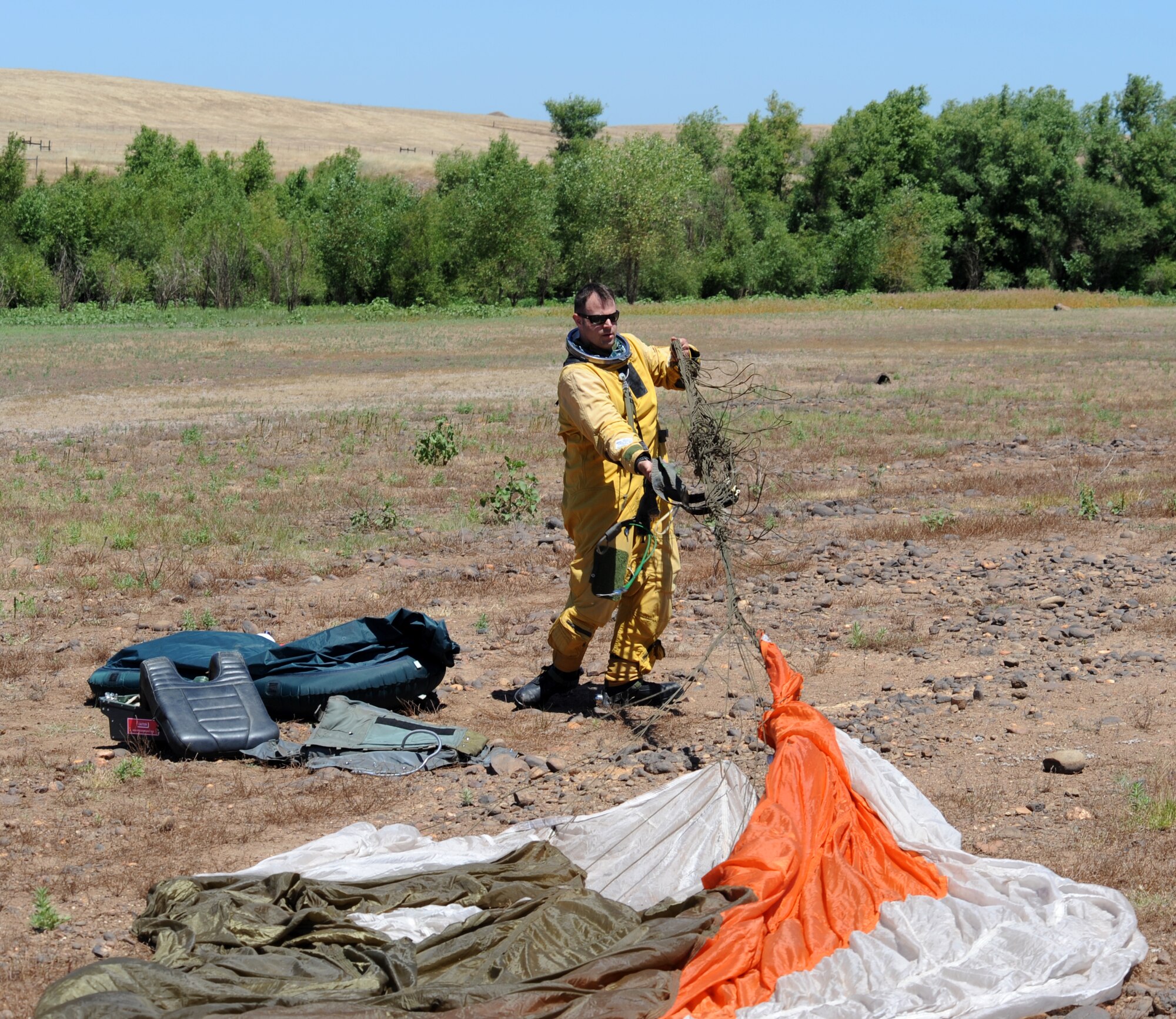 A U-2 pilot gathers his parachute during a combat search and rescue exercise at Beale Air Force Base, Calif., May 31, 2013. U-2 pilots must wear specialized pressure suits to fly at high altitudes. (U.S. Air Force photo by Sean Bhakta/Released)