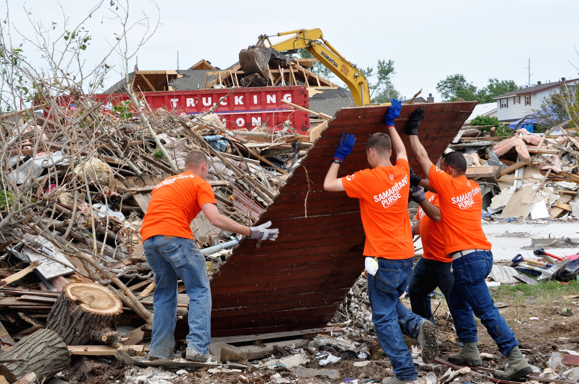 June 8, several airmen work hard to lift debris onto the ever growing pile caused by the destructive winds of the EF-5 (Enhanced Fujita Scale) tornado that tore through Moore, Okla. May 20. Over 1,150 homes were destroyed by the tornado. (U.S. Air Force photo/Kimberly Goff /Released)