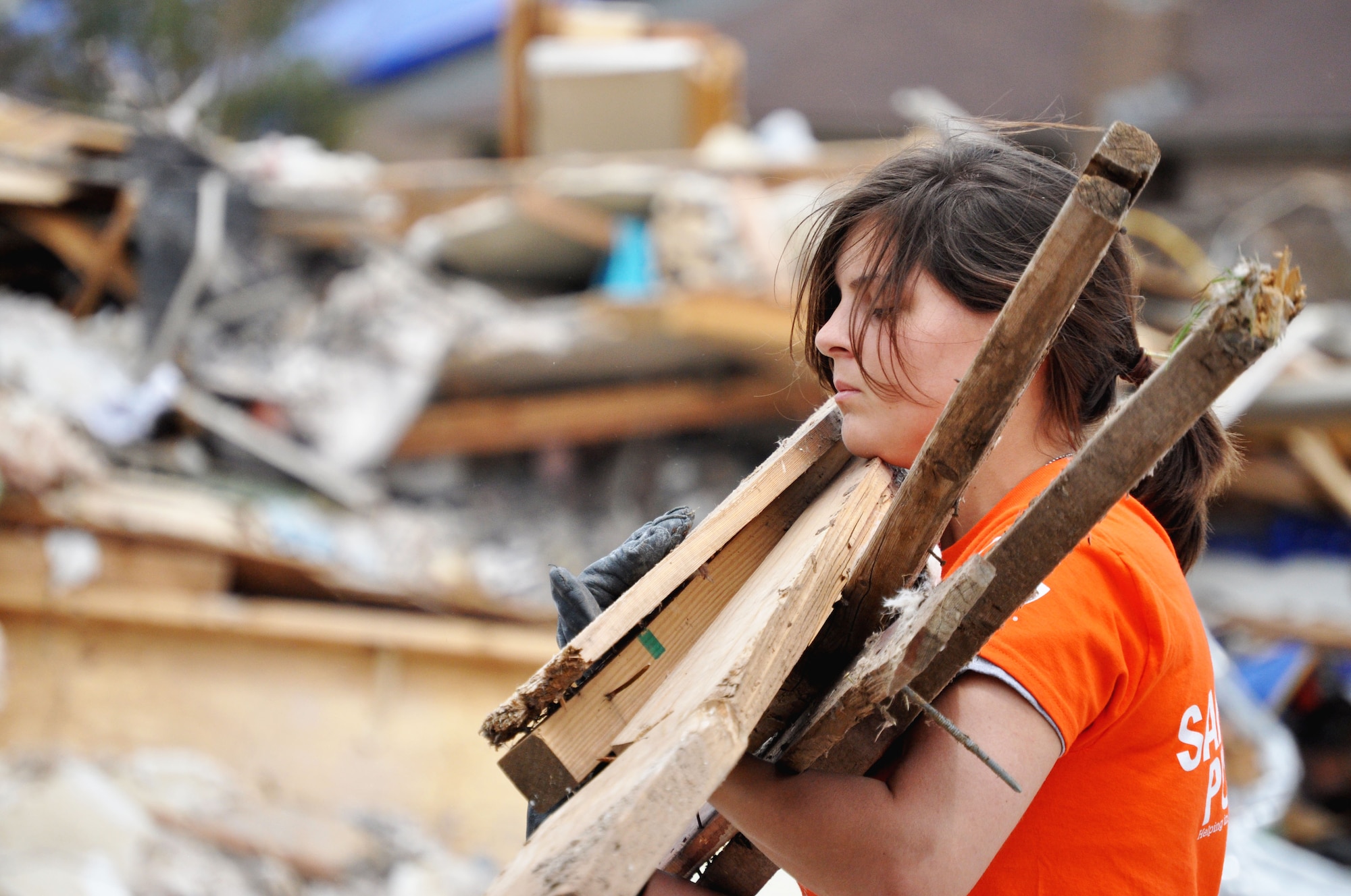 Airman Basic Brittany Orellana, 363rd Training Squadron, Sheppard Air Force Base, Texas, carries debris June 8, 2013, from the ravaged houses caused by the EF-5 (Enhanced Fujita Scale) tornado that violently blew through Moore, Okla. May 20 towards the ever growing pile. More than 100 people were rescued from the rubble caused by the twister May 20. (U.S. Air Force photo/Kimberly Goff /Released)