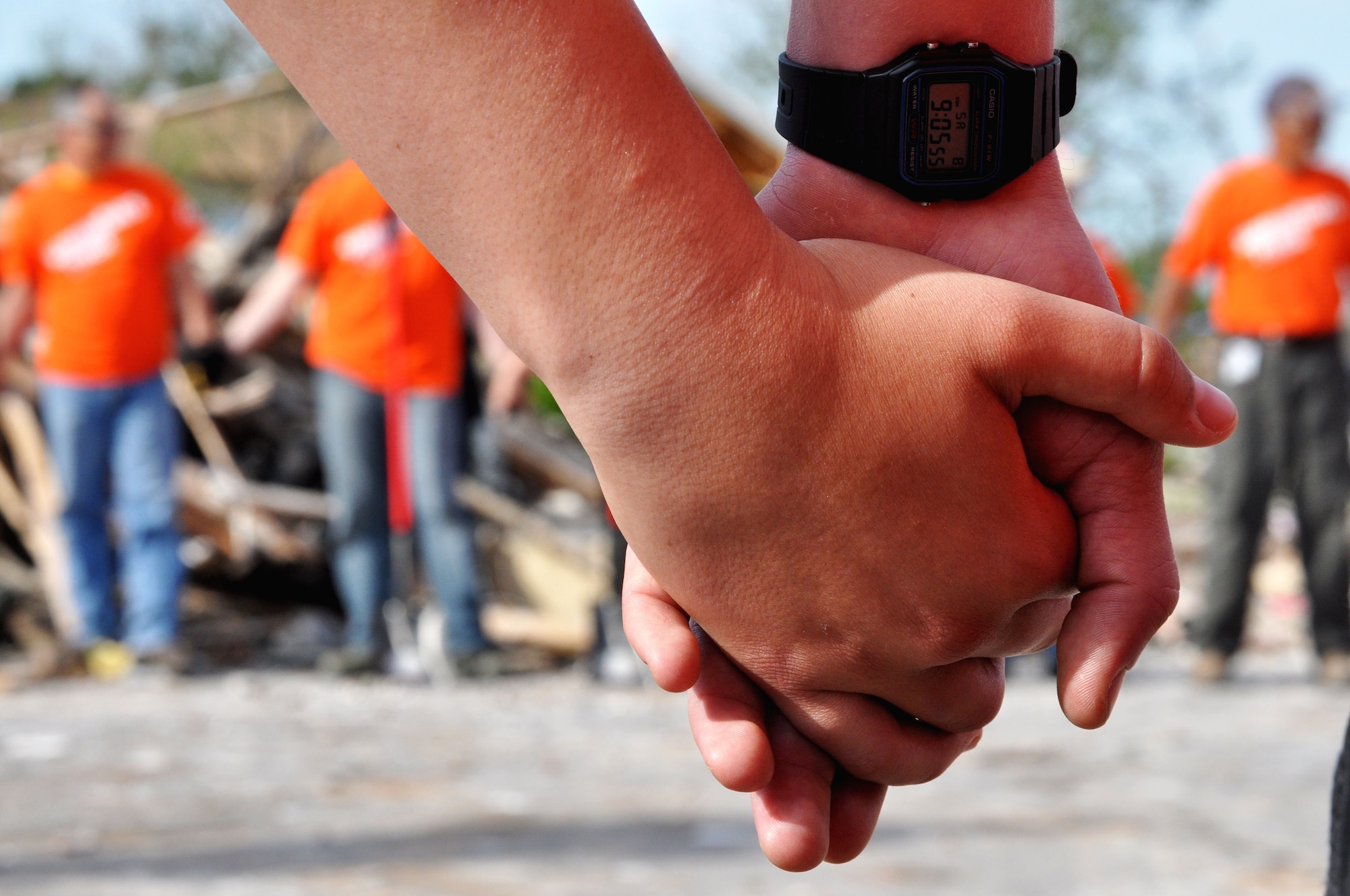 Airmen from Sheppard hold hands as they pray for those affected by the May 20 EF-5 (Enhanced Fujita Scale) tornado that cut a swath through the neighborhoods of Moore, Okla. before they begin to help clean the debris caused by the 210 mph winds June 8. The tornado killed 23, including 7 children, and injured 377 people. (U.S. Air Force photo/Kimberly Goff /Released)