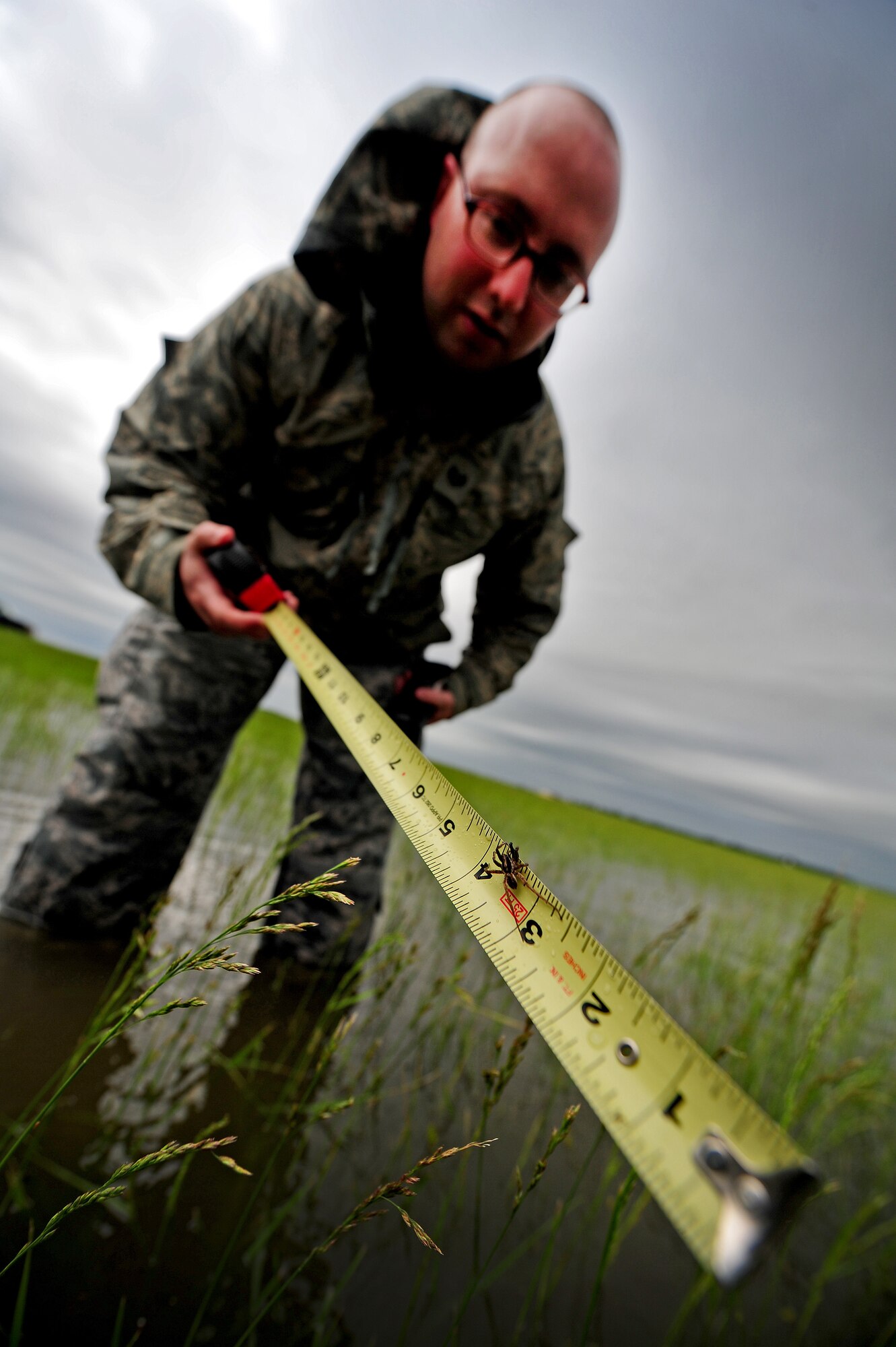 Staff Sgt. Timothy Cole, 509th Operations Support Squadron airfield management operations supervisor, discovers that rainwater buildup on the flightline can create a habitat for wolf spiders during a rainwater assessment at Whiteman Air Force Base, Mo., May 31, 2013. Additionally, rainwater can also attract birds, which pose a potential threat to aircraft on the flightline and in the air. (U.S. Air Force photo by Staff Sgt. Nick Wilson/Released)