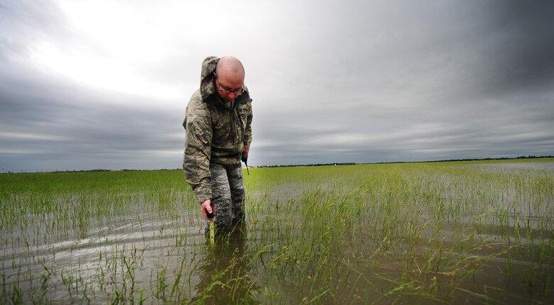 Staff Sgt. Timothy Cole, 509th Operations Support Squadron airfield management operations supervisor, conducts a rainwater assessment at Whiteman Air Force Base, Mo., May 31, 2013. The rainwater assessments are part of a daily inspection airfield managers complete at least 12 times a day. The safety of Whiteman's airfield depends on the expertise of airfield managers. (U.S. Air Force photo by Staff Sgt. Nick Wilson/Released)