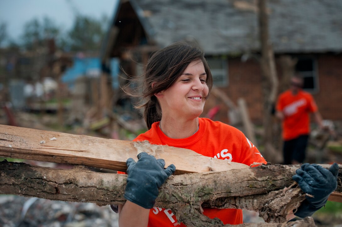Airman Basic Brittany Orellana, 363rd Training Squadron, Sheppard Air Force Base, Texas, carries tornado debris June 8 left in a Moore, Okla., neighborhood.   An EF-5 (Enhanced Fujita scale rating) tornado ripped through the central Oklahoma town May 20 with winds in excess of 210 mph winds. The twister was reportedly on the ground for 39 minutes and carved a path through neighborhoods for more than 17 miles. Orellana is an Airman in Training in ammunition and is from Mukilteo, Wa. (U.S. Air Force photo/Staff Sgt. Mike Meares)