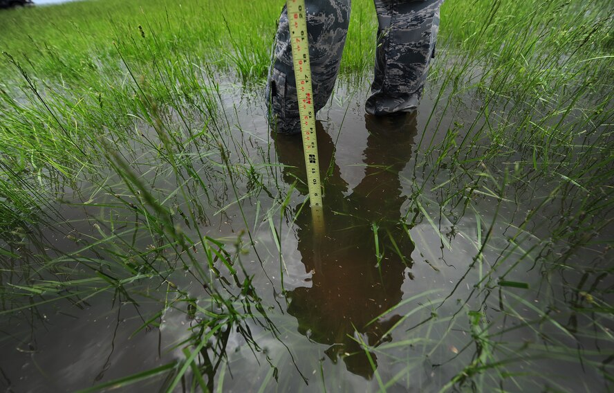 Staff Sgt. Timothy Cole, 509th Operations Support Squadron airfield management operations supervisor, measures the depth of rainwater during a during a daily safety inspection at Whiteman Air Force Base, Mo., May 31, 2013. In addition to the daily inspections, the managers also complete an annual inspection on the condition of the airfield, which is sent to Air Force Global Strike Command and used to set expectations for the following year. (U.S. Air Force photo by Staff Sgt. Nick Wilson/Released)