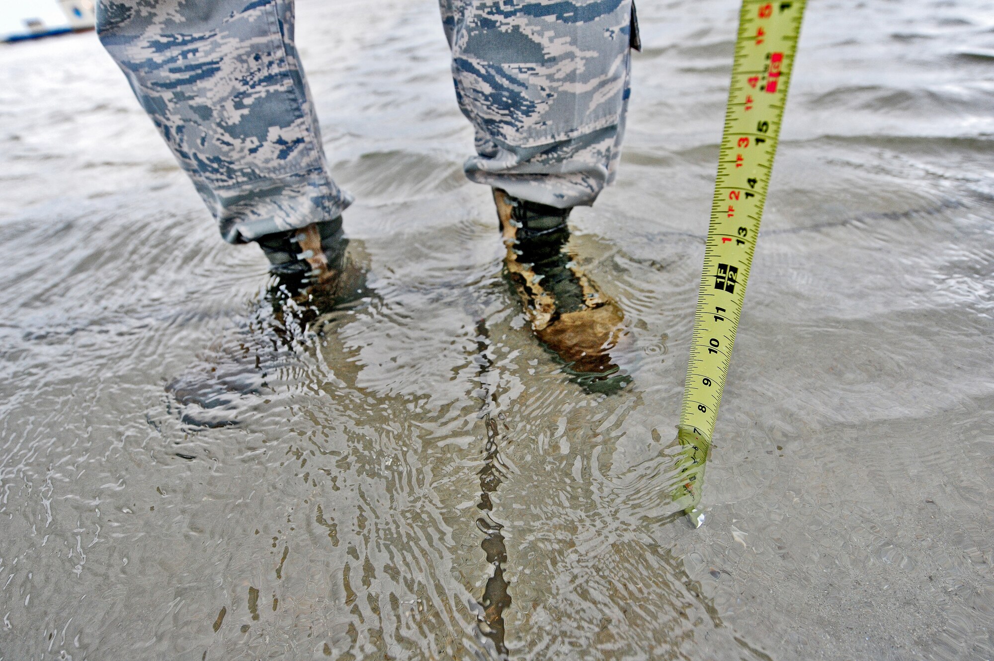 Staff Sgt. Timothy Cole, 509th Operations Support Squadron airfield management operations supervisor, measures the depth of rainwater during a during a daily safety inspection at Whiteman Air Force Base, Mo., May 31, 2013. Airfield managers must ensure safe flight conditions for any aircraft on the runway. (U.S. Air Force photo by Staff Sgt. Nick Wilson/Released)