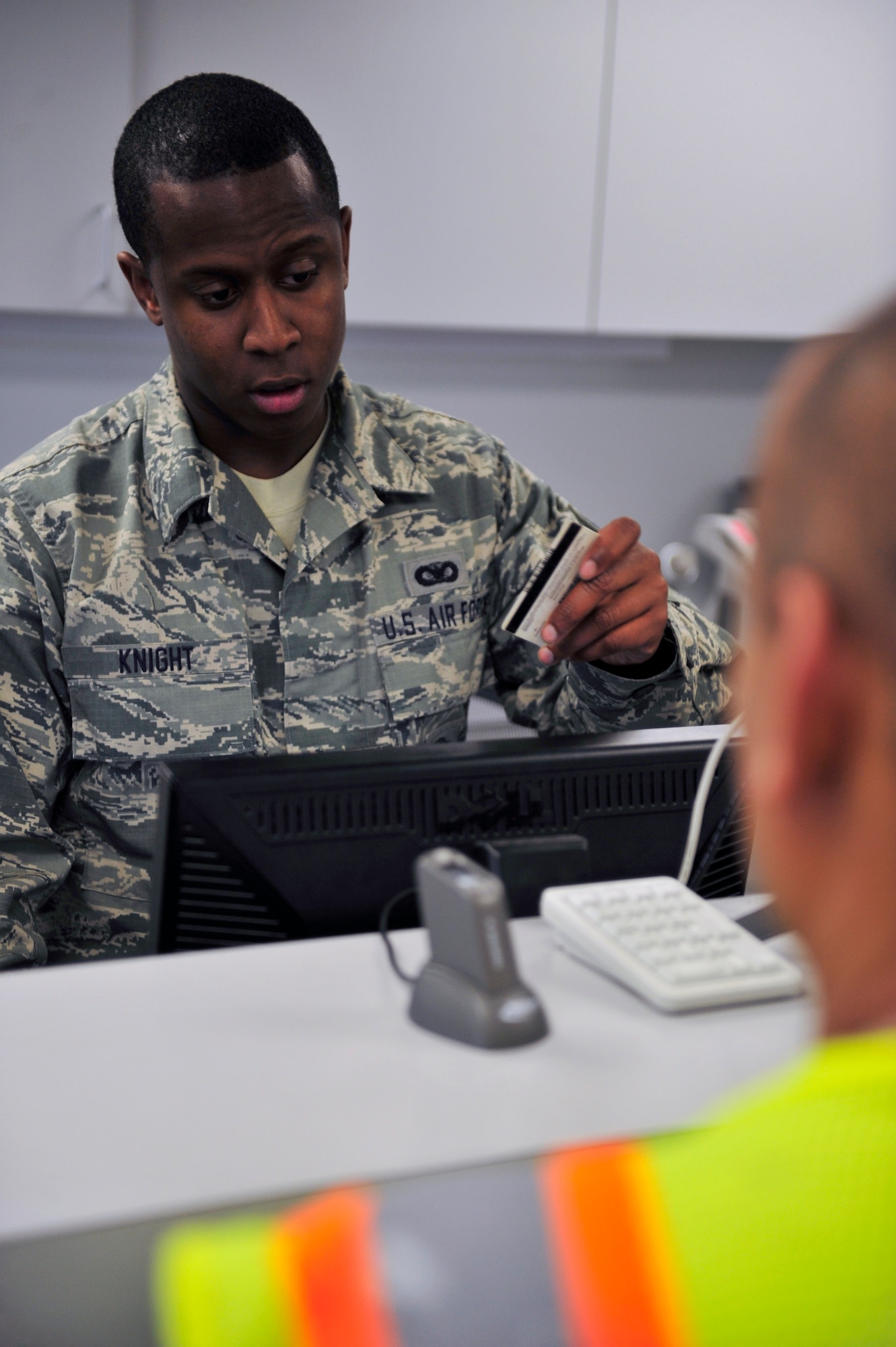 Senior Airman Brandon Knight, 460th Security Forces Squadron, checks an identification card and verifies information on the Defense Biometric Identification System June 5, 2013, on Buckley Air Force Base, Colo. DBIDS is a force protection and identity management program that manages people, property and installation access. (U.S. Air Force photo by Airman 1st Class Darryl Bolden Jr./Released)