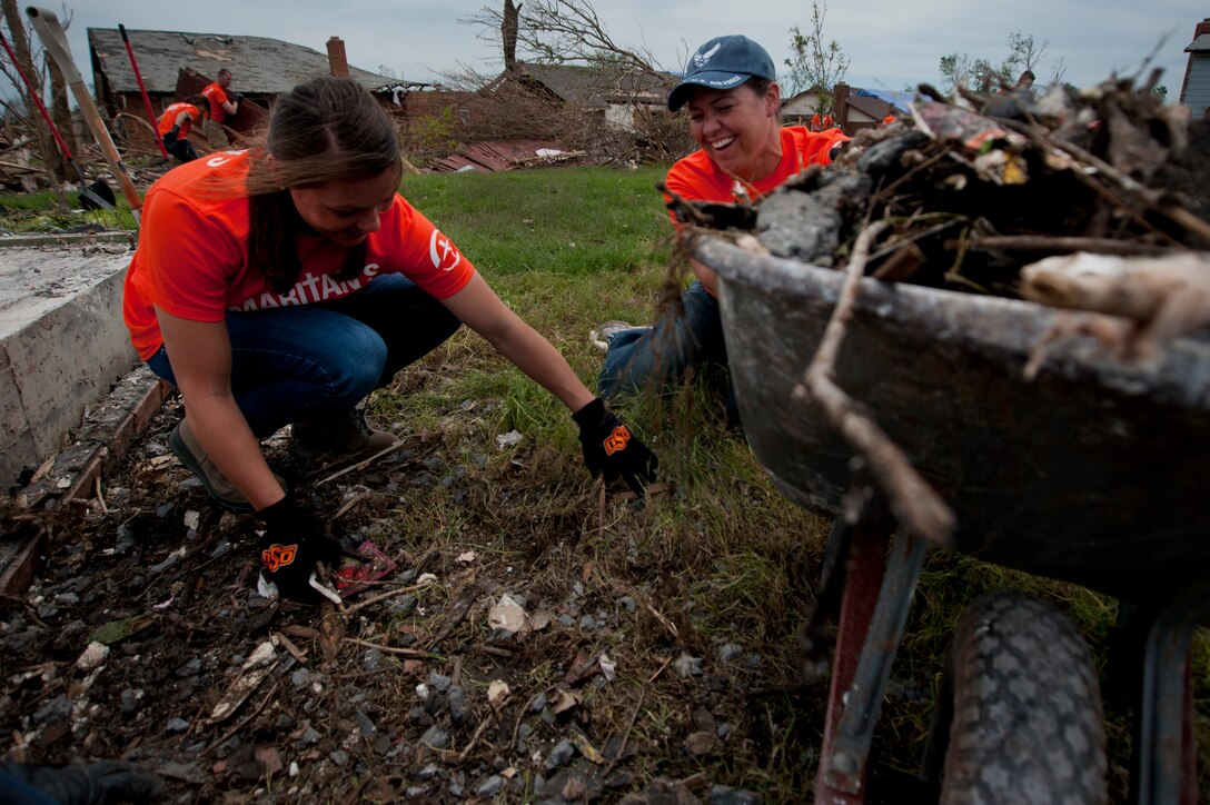 Airman Rebecca Martin and Airman 1st Class Wendy Ozburn, with the 365th and 361st Training Squadrons respectively, clean up debris June 8 left by an EF-5 (Enhanced Fujita scale rating) twister in Moore, Okla. The May 20 storm produced a large tornado reportedly on the ground for 39 minutes and carved a path through neighborhoods for more than 17 miles. More than 70 Airmen from Sheppard Air Force Base, Texas, went the day on the chapel sponsored clean up. (U.S. Air Force photo/Staff Sgt. Mike Meares/Released)