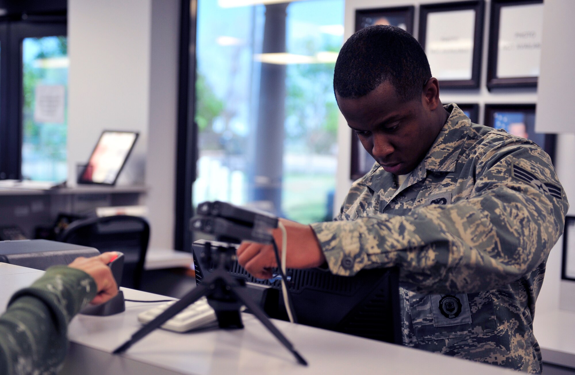 Senior Airman Brandon Knight, 460th Security Forces Squadron, makes a temporary access pass June 5, 2013, at the visitor’s center on Buckley Air Force Base, Colo. The visitor’s center is located just outside the 6th Avenue Gate and is the first stop for individuals requesting base access. The hours of operation for the visitor’s center are 7 a.m. to 5 p.m. Monday through Friday and closed on weekends. (U.S. Air Force photo by Airman 1st Class Darryl Bolden Jr./Released)