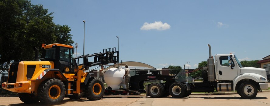 2nd Civil Engineer Squadron Heavy Repair Airmen, move a compressed natural gas pump onto a flatbed truck on Barksdale Air Force Base, La., June 10, 2013. The gas pumps, outdated and no longer being used, will be brought to the Defense Reutilization and Marketing Office for proper disposal. (U.S. Air Force photo/Senior Airman Kristin High)