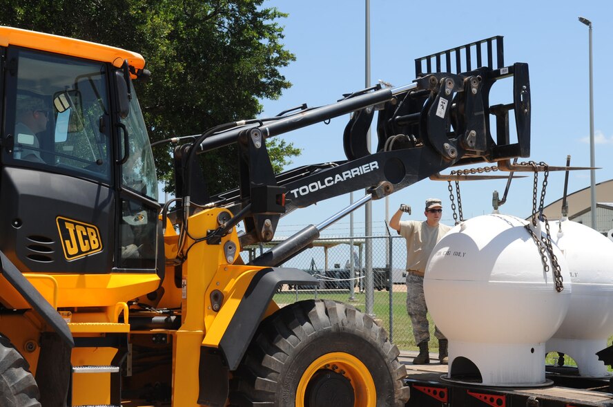Tech. Sgt. Floyd Butkiewicz, from the 2nd Civil Engineer Squadron Heavy repair section, guides a compressed natural gas pump onto a flatbed truck on Barksdale Air Force Base, La., June 10, 2013. The gas pumps, outdated and no longer being used, will be brought to the Defense Reutilization and Marketing Office for proper disposal. (U.S. Air Force photo/Senior Airman Kristin High)