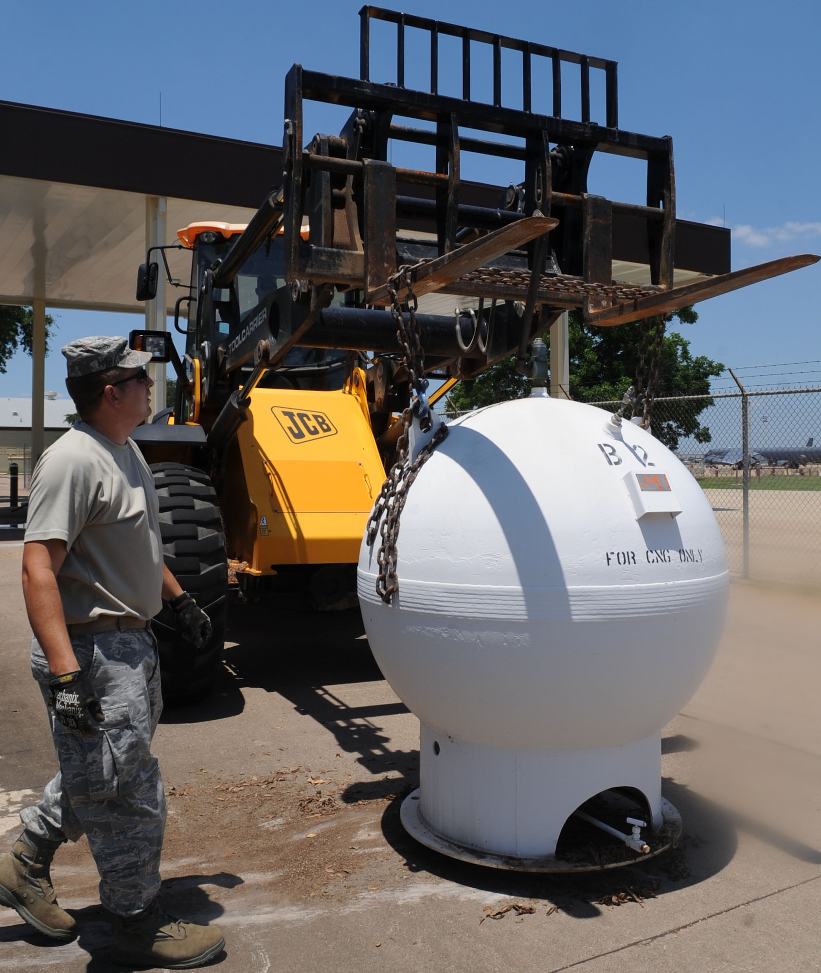 Tech. Sgt. Floyd Butkiewicz, from the 2nd Civil Engineer Squadron Heavy Repair section, checks a chain holding a compressed natural gas pump on Barksdale Air Force Base, La., June 10, 2013. The gas pumps, outdated and no longer being used, will be brought to the Defense Reutilization and Marketing Office for proper disposal. (U.S. Air Force photo/Senior Airman Kristin High)