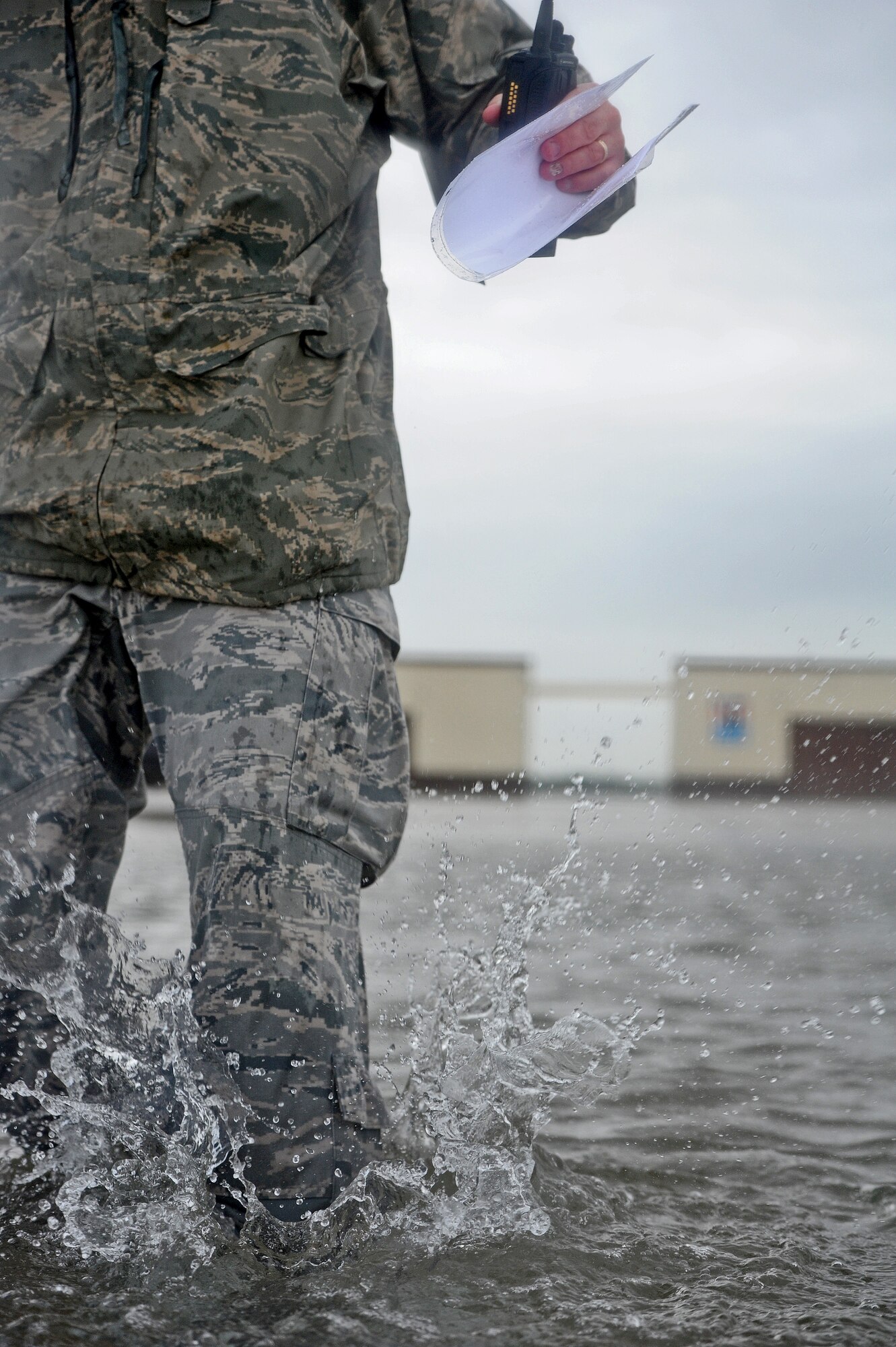Staff Sgt. Timothy Cole, 509th Operations Support Squadron airfield management operations supervisor, treads through water that is almost knee-high to conduct a rainwater assessment at Whiteman Air Force Base, Mo., May 31, 2013. Airfield Management's responsibilities include providing support to various aircraft operations and enabling continuation of operations after emergency situations. (U.S. Air Force photo by Staff Sgt. Nick Wilson/Released)