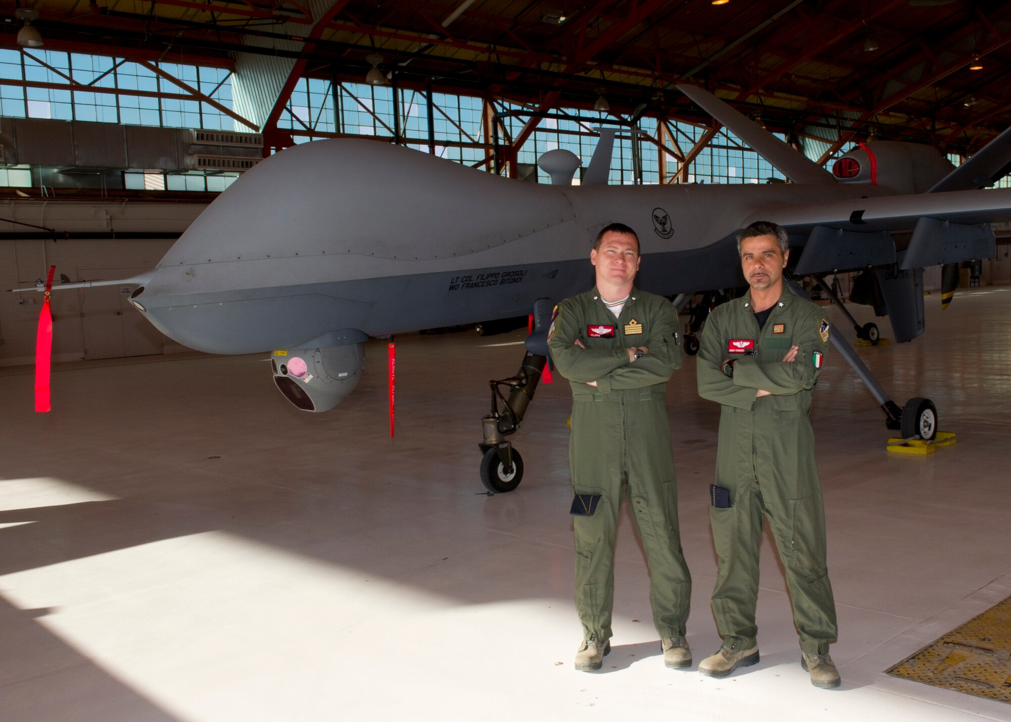 Italian air force Lt. Col. Filippo Grosoli, 29th Attack Squadron MQ-9 Reaper pilot, and Italian air force Chief Master Sgt. Francesco Bitondi, 29th ATKS MQ-9 sensor operator, stand in front of an MQ-9 at Holloman Air Force Base, N.M., May 29. Grosoli and Bitondi are part of an exchange program between United States and Italy. (U.S. Air Force photo by Senior Airman Kasey Close/Released)