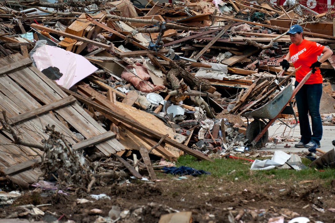 Airman 1st Class Wendy Ozburn, 361st Training Squadron, Sheppard Air Force Base, Texas, dumps a full wheelbarrow of debris June 8 left by a tornado that ripped though Moore, Okla., May 20. The EF-5 (Enhanced Fujita scale rating) tornado reportedly caused an estimated $2 billion in damage. In all, somewhere between 12,000 and 13,000 homes were destroyed. Ozburn, of Fresno, Calif., said, “When you stop and look out, the totality of it all is overwhelming.” (U.S. Air Force photo/Staff Sgt. Mike Meares/Released)