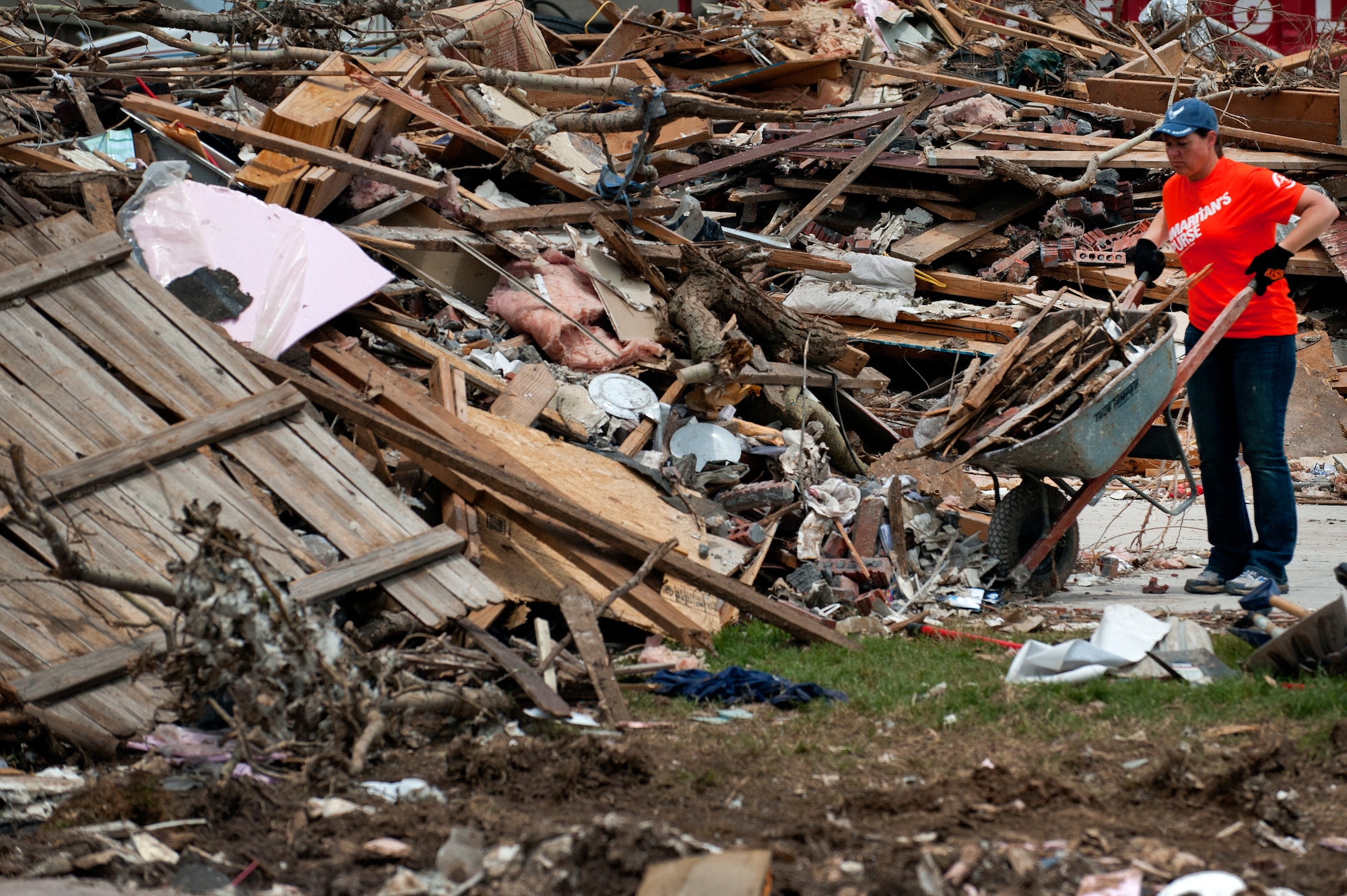 Airman 1st Class Wendy Ozburn, 361st Training Squadron, Sheppard Air Force Base, Texas, dumps a full wheelbarrow of debris June 8 left by a tornado that ripped though Moore, Okla., May 20. The EF-5 (Enhanced Fujita scale rating) tornado reportedly caused an estimated $2 billion in damage. In all, somewhere between 12,000 and 13,000 homes were destroyed. Ozburn, of Fresno, Calif., said, “When you stop and look out, the totality of it all is overwhelming.” (U.S. Air Force photo/Staff Sgt. Mike Meares/Released)