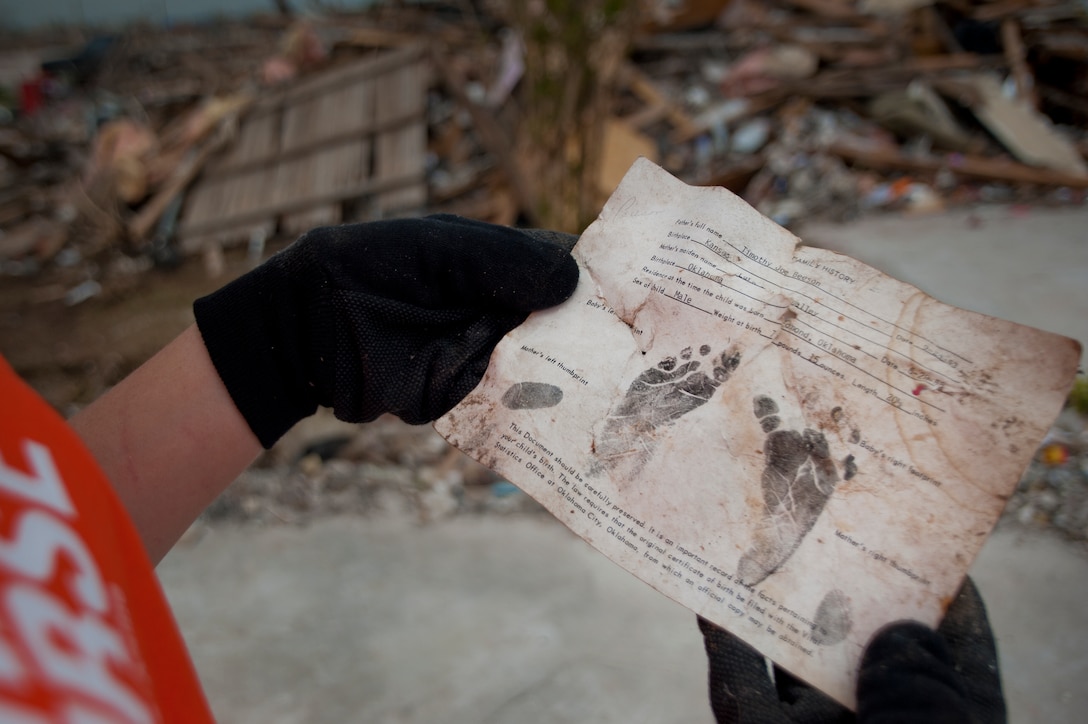 A birth certificate was uncovered in the debris left by an E F-5 (Enhanced Fujita scale rating) tornado tore through Moore, Okla., May 20. More than 70 Airmen from Sheppard Air Force Base, Texas, spent June 8 helping clean up debris along the 17-mile path where the twister carved through Oklahoma. The twister spanned more than 1.25 miles in width at the greatest point. (U.S. Air Force photo/Staff Sgt. Mike Meares/Released)