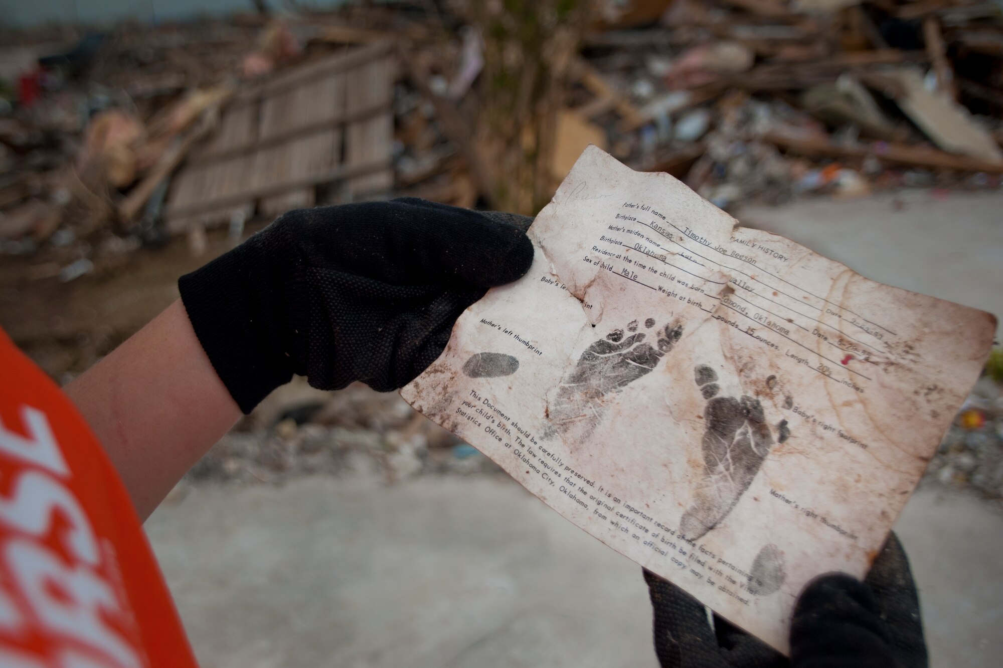 A birth certificate was uncovered in the debris left by an E F-5 (Enhanced Fujita scale rating) tornado tore through Moore, Okla., May 20. More than 70 Airmen from Sheppard Air Force Base, Texas, spent June 8 helping clean up debris along the 17-mile path where the twister carved through Oklahoma. The twister spanned more than 1.25 miles in width at the greatest point. (U.S. Air Force photo/Staff Sgt. Mike Meares/Released)
