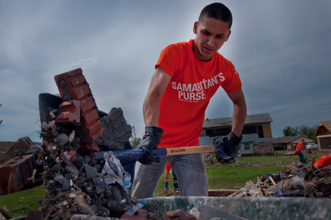 Airman Basic Zach Manzella, 363rd Training Squadron, Sheppard Air Force Base, Texas, shovels debris left by a tornado into a wheelbarrow in Moore, Okla., June 8, during a chapel sponsored event. The EF-5 (Enhanced Fujita scale rating) tornado that struck May 20 caused an estimated $2 billion in damage. In all, somewhere between 12,000 and 13,000 homes were destroyed. More than 70 Airmen in Training made the trip. Manzella’s hometown is Kent, Ohio. (U.S. Air Force photo/Staff Sgt. Mike Meares/Released)