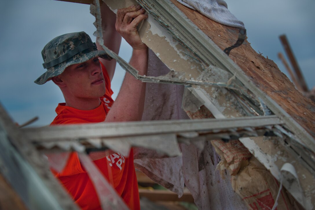 Airman 1st Class Matt McCammon, 366th Training Squadron, Sheppard Air Force Base, Texas, flips a wall section of a house with shattered windows while helping cleanup debris June 8 left by a tornado that devastated the town of Moore, Okla. An EF-5 (Enhanced Fujita scale rating) tornado ripped through the central Oklahoma town May 20 with winds in excess of 210 mph winds. The twister was reportedly on the ground for 39 minutes and carved a path through neighborhoods for more than 17 miles. (U.S. Air Force photo/Staff Sgt. Mike Meares/Released)