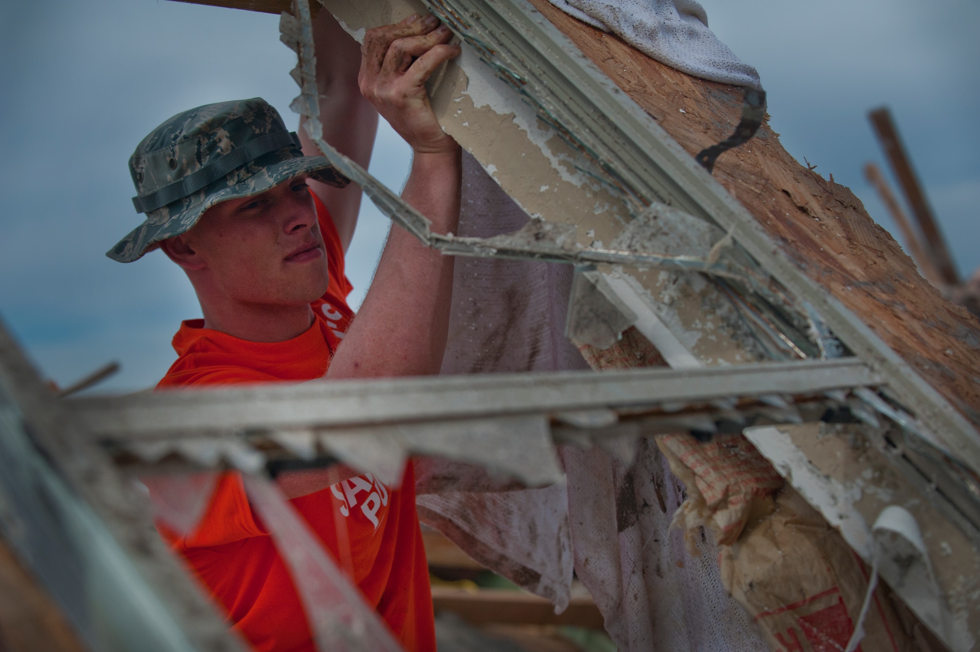 Airman 1st Class Matt McCammon, 366th Training Squadron, Sheppard Air Force Base, Texas, flips a wall section of a house with shattered windows while helping cleanup debris June 8 left by a tornado that devastated the town of Moore, Okla. An EF-5 (Enhanced Fujita scale rating) tornado ripped through the central Oklahoma town May 20 with winds in excess of 210 mph winds. The twister was reportedly on the ground for 39 minutes and carved a path through neighborhoods for more than 17 miles. (U.S. Air Force photo/Staff Sgt. Mike Meares/Released)