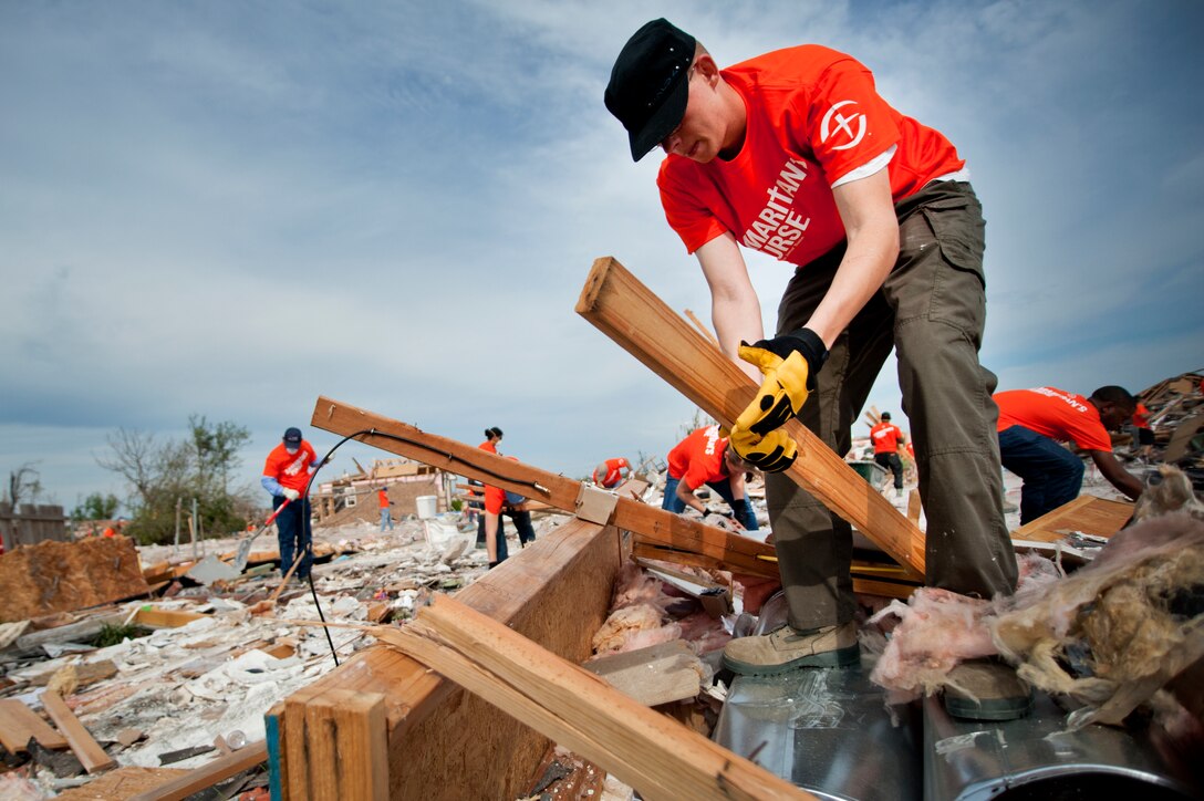 Airman 1st Class Aaron Church, 362nd Training Squadron, Sheppard Air Force Base, Texas, cleans up debris during a chapel sponsored trip to Moore, Okla., June 8. An EF-5 (Enhanced Fujita scale rating) tornado ripped through the central Oklahoma town May 20 with winds in excess of 210 mph winds. The twister killed 23, including seven children at Plaza Towers Elementary School, and injured 377. Church is from Alexandria, Va., and is in training to be an F-16 crew chief. (U.S. Air Force photo/Staff Sgt. Mike Meares/Released)