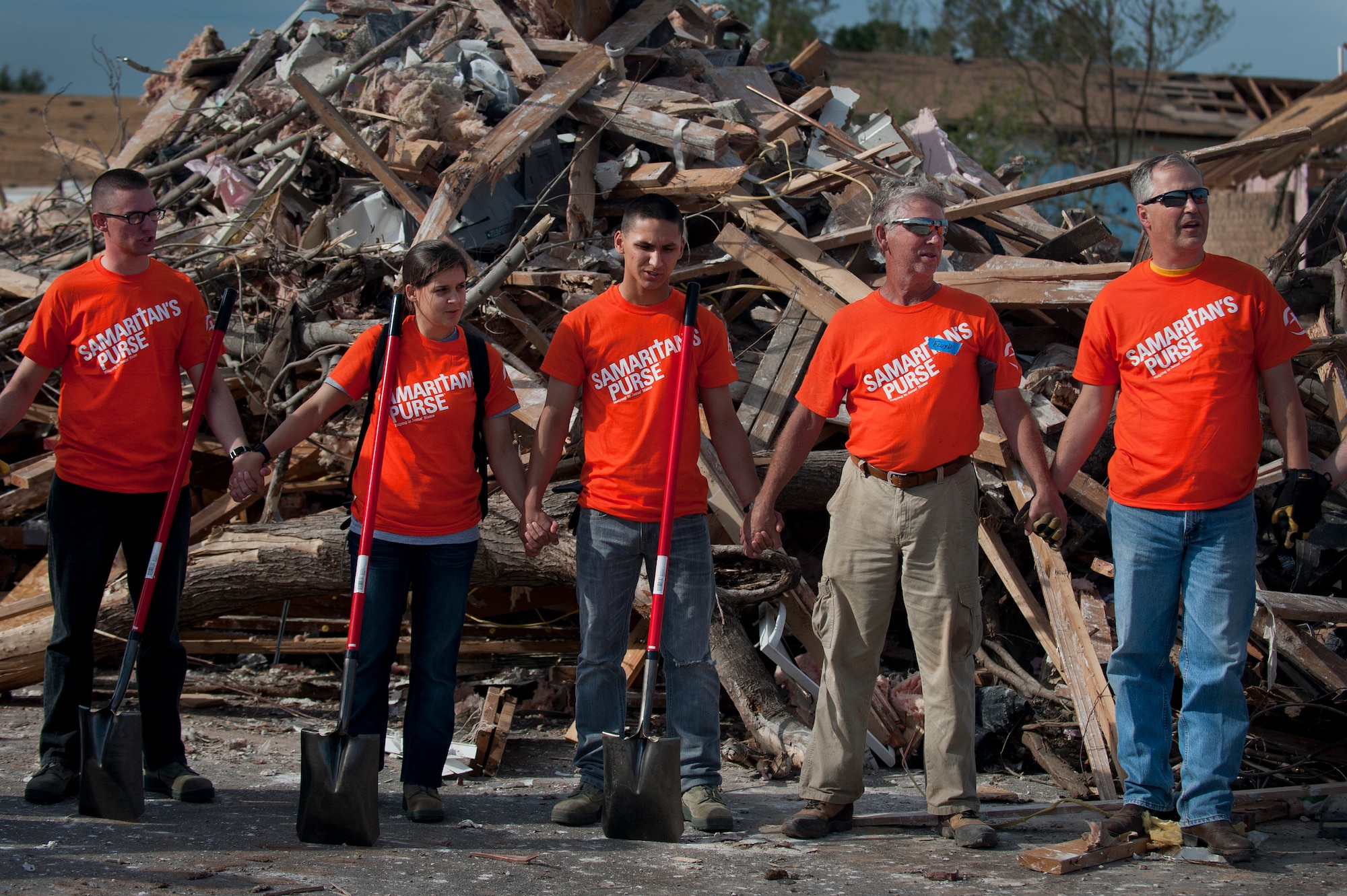 Airmen from Sheppard Air Force Base, Texas, join hands and pray for the victims of the June 8 tornado in Moore, Okla. The Airmen drove the more than two-hour trip to help clean up debris during a chapel sponsored trip to. An EF-5 (Enhanced Fujita scale rating) tornado ripped through the central Oklahoma town May 20 with winds in excess of 210 mph winds. (U.S. Air Force photo/Staff Sgt. Mike Meares/Released)