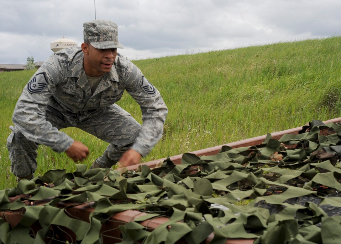 Master Sgt. Correy Hodge, 28th Medical Support Squadron medical material flight chief, approaches the low-crawl obstacle during the Warrior Challenge at Ellsworth Air Force Base, S.D., June 5, 2013. The low-crawl obstacle was one of several activities including weapons disassembly and reassembly stage, a self aid and buddy care scenario, and an improvised explosive device exercise where teams implemented their tactical skills and tested their readiness knowledge. (U.S. Air Force photo by Airman 1st Class Anania Tekurio/Released)