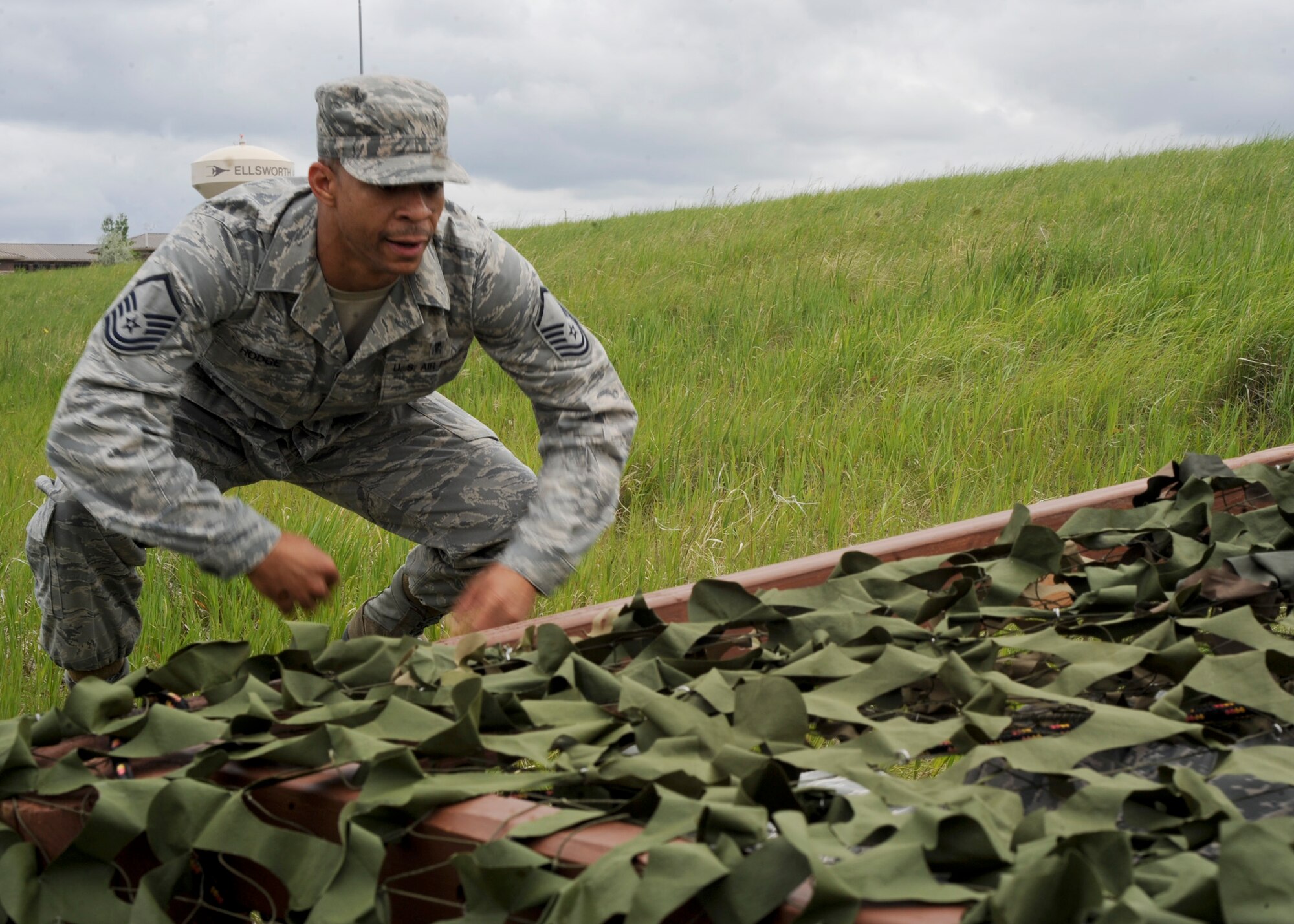 Master Sgt. Correy Hodge, 28th Medical Support Squadron medical material flight chief, approaches the low-crawl obstacle during the Warrior Challenge at Ellsworth Air Force Base, S.D., June 5, 2013. The low-crawl obstacle was one of several activities including weapons disassembly and reassembly stage, a self aid and buddy care scenario, and an improvised explosive device exercise where teams implemented their tactical skills and tested their readiness knowledge. (U.S. Air Force photo by Airman 1st Class Anania Tekurio/Released)