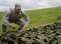 Master Sgt. Correy Hodge, 28th Medical Support Squadron medical material flight chief, approaches the low-crawl obstacle during the Warrior Challenge at Ellsworth Air Force Base, S.D., June 5, 2013. The low-crawl obstacle was one of several activities including weapons disassembly and reassembly stage, a self aid and buddy care scenario, and an improvised explosive device exercise where teams implemented their tactical skills and tested their readiness knowledge. (U.S. Air Force photo by Airman 1st Class Anania Tekurio/Released)