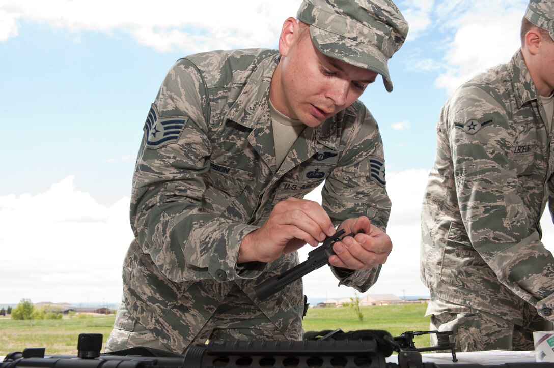Staff Sgt. David Gipson, 432nd Attack Squadron MQ-9 Reaper sensor operator, disassembles an M-4 carbine rifle at a skills station during the Warrior Challenge at Ellsworth Air Force Base, S.D., June 5, 2013. The course featured six obstacles including weapon disassembly and re-assembly, a self aid and buddy care scenario and improvised explosive device identification walk to test stamina, combat skills and teamwork capabilities. (U.S. Air Force photo by Airman 1st Class Alystria Maurer/Released) 