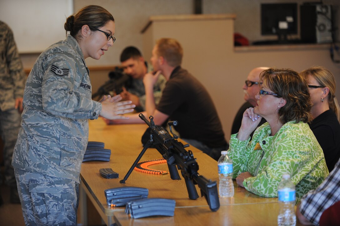 Staff Sgt. Elizabeth Sheppard, 28th Security Forces Squadron combat arms instructor, explains the characteristics of the M-249 automatic rifle to Linda Rabe, Rapid City Area Chamber of Commerce president and honorary commander for the 28th Bomb Wing vice commander, during an honorary commander tour at Ellsworth Air Force Base, S.D.,  June 7, 2013.  Attendees participated in a new active shooter training course, combat arms displays and military working dog demonstrations. (U.S. Air Force photo by Master Sgt. John Barton/Released) 