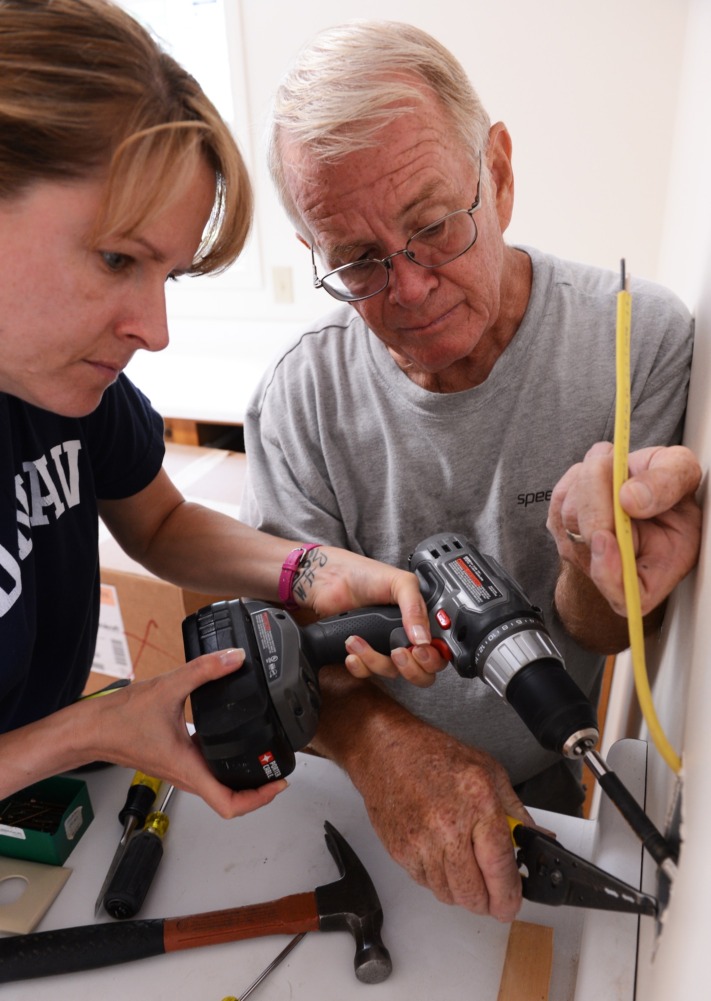 Robert Brown, Habitat for Humanity construction director, and retired  need service and rank Michelle Huff, Habitat for Humanity volunteer, install an outlet in a Habitat for Humanity home in Sumter, S.C., May 29, 2013 Hundreds of Team Shaw members volunteer with habitat to build and repair homes in the local area. (U.S. Air Force photo by Senior Airman Tabatha Zarrella/Released)
