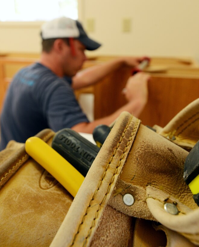 Nathan Davis, volunteer for Habitat for Humanity, secures a cabinet for a newly built Habitat for Humanity home in Sumter, S.C., May 29, 2013. Hundreds of Team Shaw members volunteer with habitat to build and repair homes in the local area. (U.S. Air Force photo by Senior Airman Tabatha Zarrella/Released)