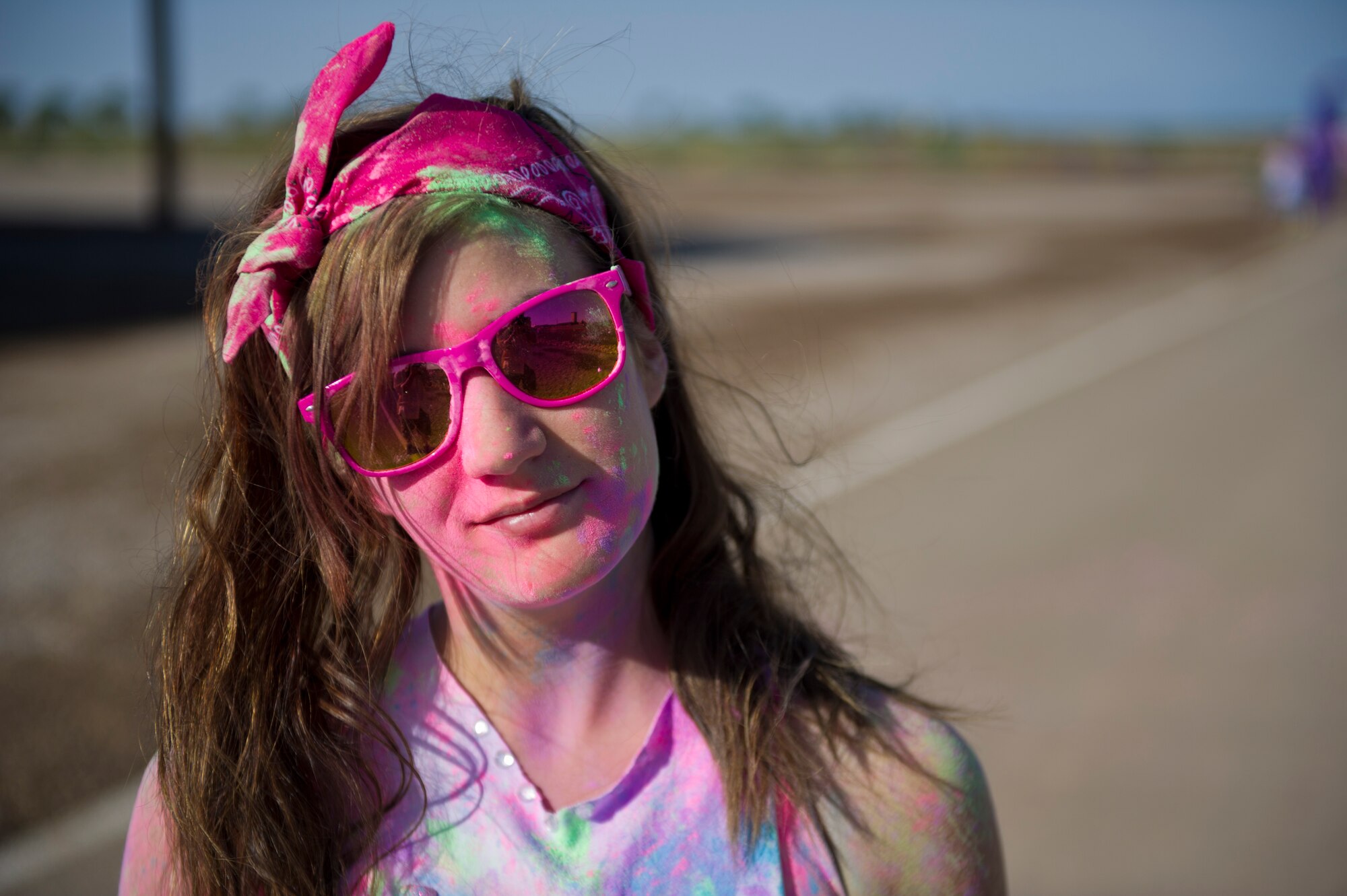 Airman 1st Class Leah Murray, 49th Wing Public Affairs photojournalist, is covered in colored corn starch powder after the Art Blast run at Holloman Air Force Base, N.M., June 8. Over 200 people of all ages participated in this morale-boosting 5k run. (U.S. Air Force photo by Airman 1st Class Aaron Montoya/Released)
