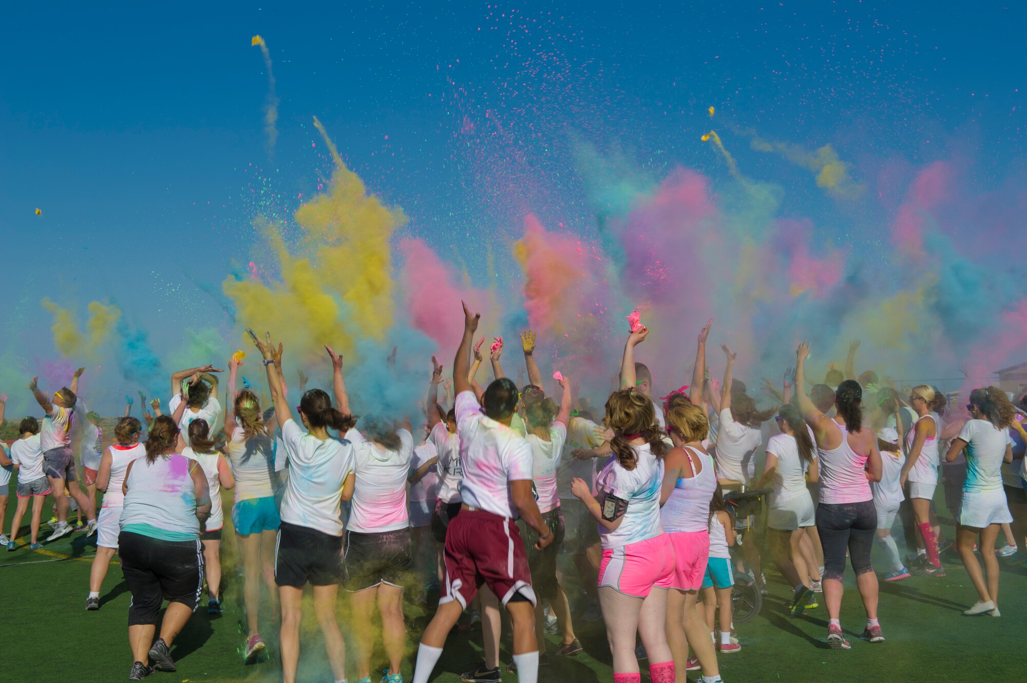 Members of Team Holloman celebrate the finish of the Art Blast run by simultaneously throwing colored corn starch powder in the air. Over 200 people of all ages participated in this morale-boosting 5k run. (U.S. Air Force photo by Airman 1st Class Aaron Montoya/Released)