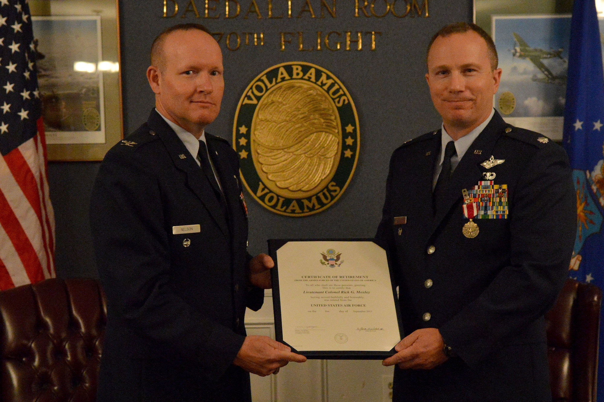U.S. Air Force Col. Robert Nelson, Air Forces Central director, presents Lt. Col. Rick Moxley, AFCNT division chief, with his retirement certificate, Shaw Air Force Base, S.C., June 7, 2013. Moxley commissioned in 1992 as a distinguished graduate of the Air Force Reserve Officer Training Corps program at Clarkson University in Potsdam, N.Y. (U.S. Air Force photo by Airman 1st Class Ashley L. Gardner/Released)