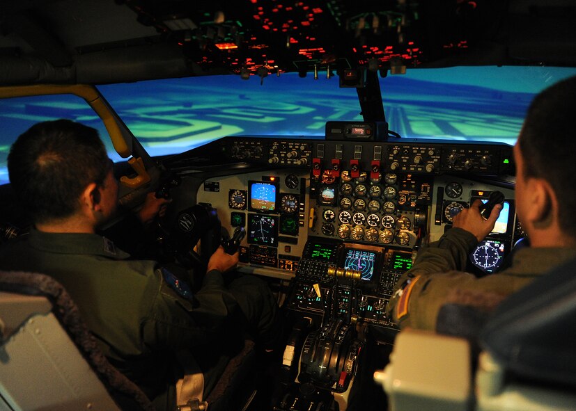 Lt. Col. Mizuru Tanikawa, Pacific Air Forces/A5I Japanese Liaison Officer, left, flies a KC-135 Stratotanker in the flight simulator with the help of 1st Lt. Frank Martinez, 96th Air Refueling Squadron KC-135 pilot, right, at the KC-135 simulator building on Joint Base Pearl Harbor-Hickam, Hawaii, June 7, 2013. (U.S. Air Force photo/Tech. Sgt. Jerome S. Tayborn)