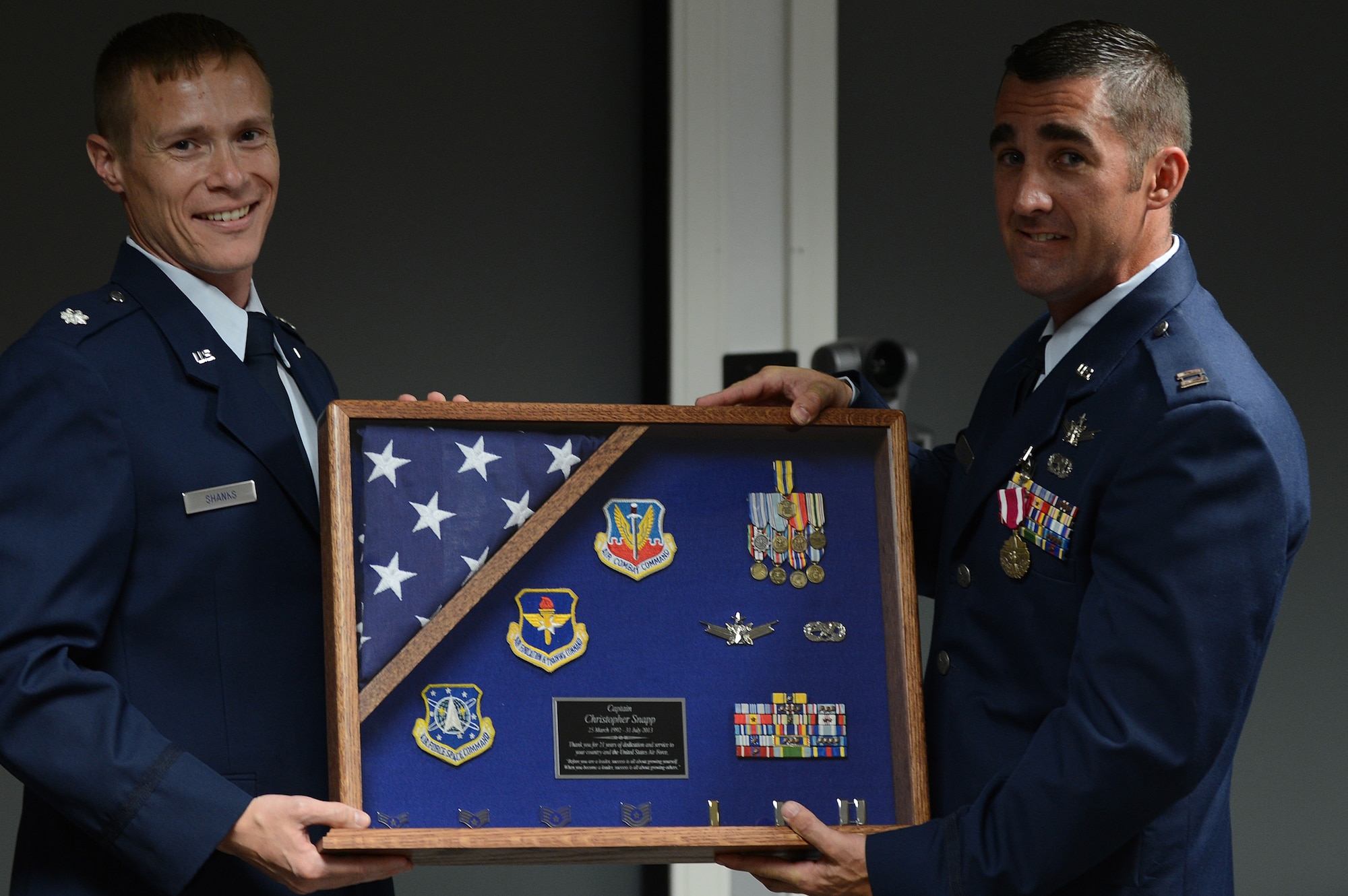 Lt. Col. Devine Shanks (left), Air Forces Central 609th Air Operations Center Detachment 1 commander, presents Capt. Christopher Snapp, AFCENT 609th AOC Detachment 1 operations flight commander, with his commemorative shadowbox as a visual reminder of his accomplishments during his Air Force career, Shaw Air Force Base, S.C., June 7, 2013. Snapp served from 1992 to 2013, and retired at the grade of captain. (U.S. Air Force photo by Airman 1st Class Daniel Blackwell/Released)