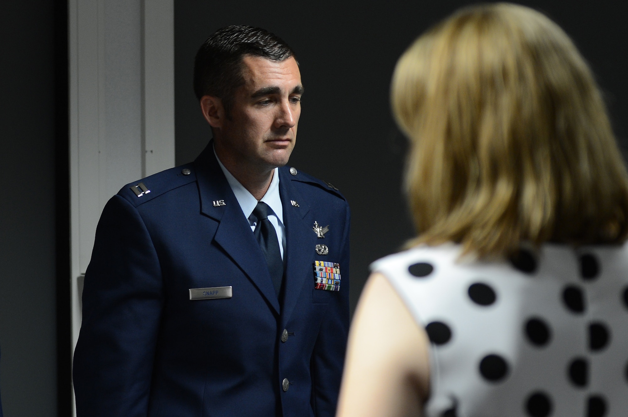 Amanda Snapp, wife of Capt. Christopher Snapp, Air Forces Central 609th Air Operations Center Detachment 1 operations flight commander, watches as her husband’s career accomplishments are listed during his retirement ceremony at Shaw Air Force Base, S.C., June 7, 2013. Snapp served from 1992 to 2013, and retired at the grade of captain. (U.S. Air Force photo by Airman 1st Class Daniel Blackwell/Released)