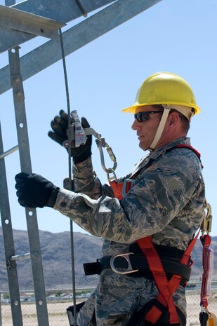 Col. Barry Cornish, 99th Air Base Wing commander, prepares to climb up the radio tower during the radio tower climbing demonstration June 7, 2013, at Nellis Air Force Base, Nev. It is necessary to climb the tower to perform maintenance on the radio antennas. (U.S. Air Force photo by Senior Airman Matthew Lancaster)