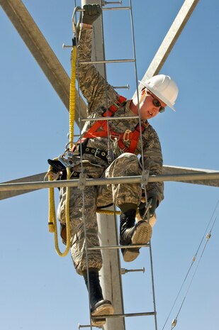 Staff Sgt. Corie Brassfield, 99th Communication Squadron airfield systems craftsman, demonstrates how to attach the climbing equipment during the tower climbing demonstration June 7, 2013, at Nellis Air Force Base, Nev. Knowing how to use the equipment is very important in ensuring you do not fall and get injured. (U.S. Air Force photo by Senior Airman Matthew Lancaster)